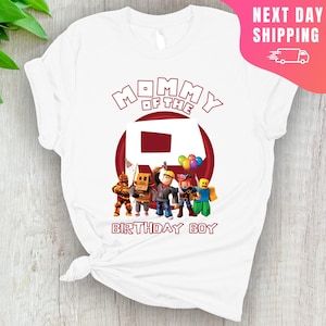 May include: White t-shirt with red text that says "Mommy of the" and a red circle with a white number "8" inside.  There are five cartoon characters standing in front of the circle.  The text "Birthday Boy" is below the circle.