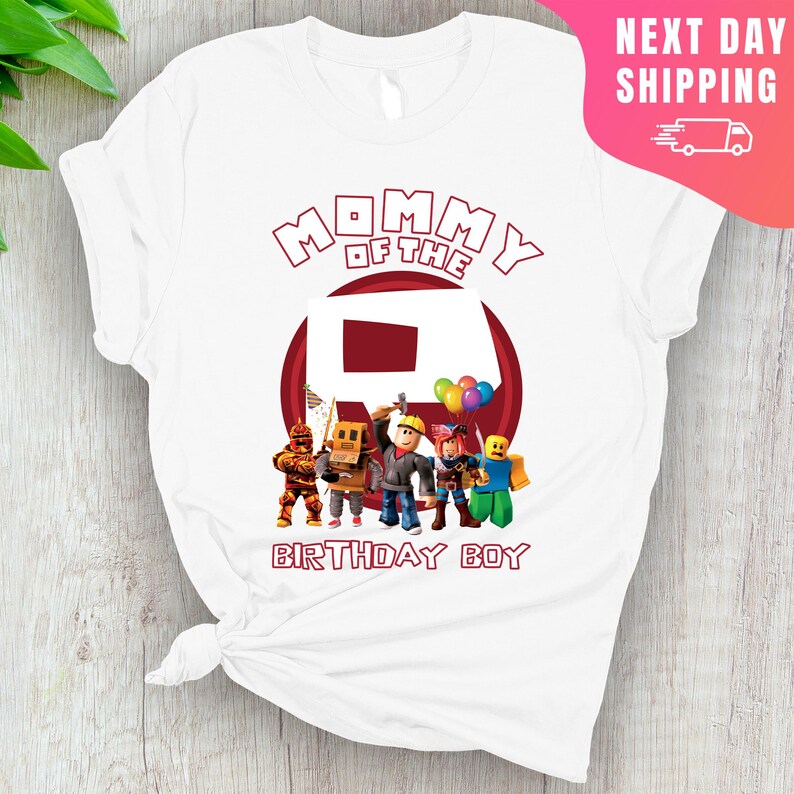 May include: White t-shirt with red text that says "Mommy of the" and a red circle with a white number "8" inside.  There are five cartoon characters standing in front of the circle.  The text "Birthday Boy" is below the circle.
