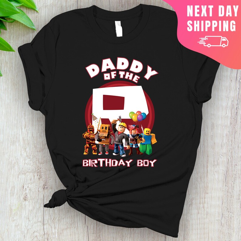 May include: Black t-shirt with a red circle and the text "Daddy of the R Birthday Boy". Inside the circle is a red letter R. There are five cartoon characters standing in front of the letter R.