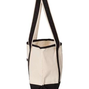 May include: A white canvas tote bag with black trim and handles. The bag has a large main compartment and a smaller pocket on the front.
