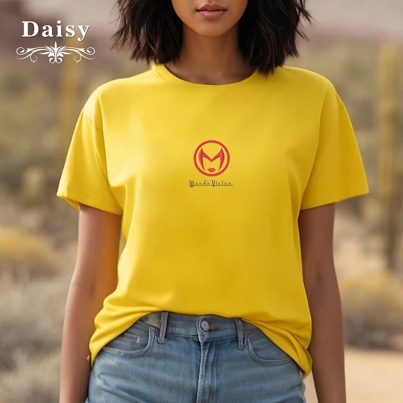 May include: Yellow short-sleeved t-shirt with a red circle logo featuring a stylised female face and the text "Wanda Vision".