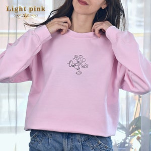 May include: Light pink sweatshirt with a black line drawing of Mickey Mouse on the front. The drawing says "Love" above Mickey Mouse.