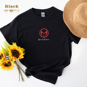 May include: Black t-shirt with a red embroidered WandaVision logo featuring a stylised Scarlet Witch face inside a circle. The text "WandaVision" is written in white below the logo.