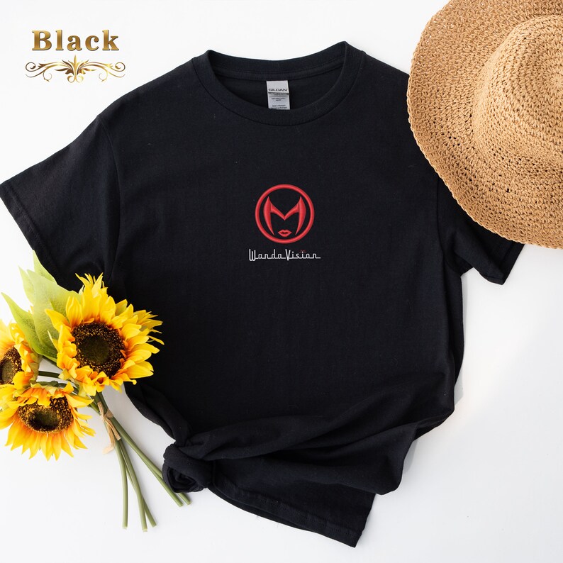 May include: Black t-shirt with a red embroidered WandaVision logo featuring a stylised Scarlet Witch face inside a circle. The text "WandaVision" is written in white below the logo.