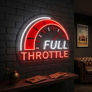 以下が含まれることがあります： 赤と白のスピードメーターのデザインと白い文字「FULL THROTTLE」のネオンサイン。サインは暗いレンガの壁に取り付けられています。ヴィンテージのオイル缶と革のドライビンググローブが下の木製の棚にあります。