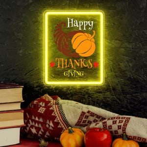 May include: A rectangular neon sign with the words "Happy Thanksgiving" and a cornucopia and pumpkin graphic. The sign is surrounded by a yellow glow. A stack of books, a patterned blanket, pumpkins, and an apple are in the foreground.
