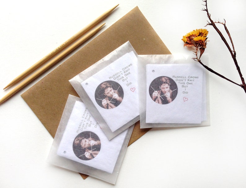 May include: Three white gift tags with a photo of Russell Crowe knitting. The text on the tags reads "Russell Crowe didn't knit this one but I did".