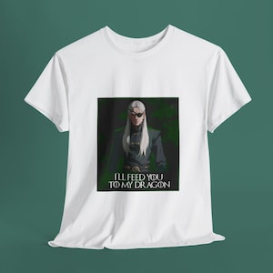 May include: White t-shirt with a graphic print of a man with a white eyepatch and long white hair. The text "I'll feed you to my dragon" is printed below the image.