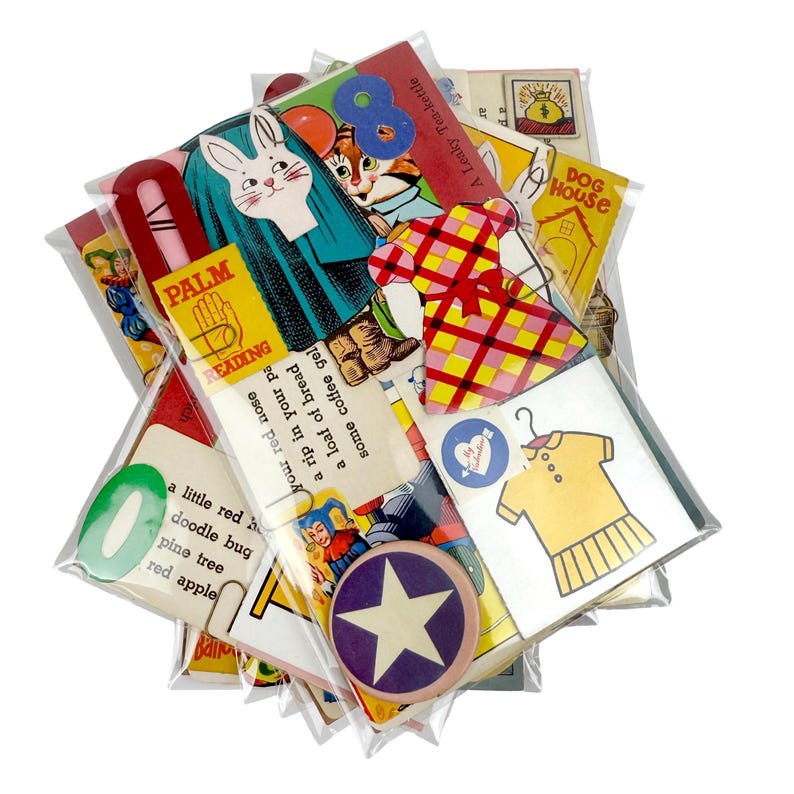 Puede incluir: Una colecci&oacute;n de ef&iacute;meras vintage, que incluye tarjetas, pegatinas y marcadores, empaquetadas en pl&aacute;stico transparente. Los art&iacute;culos presentan ilustraciones coloridas de un conejo, un vestido y el texto "Palm Reading".