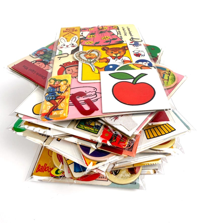Puede incluir: Una colecci&oacute;n de pegatinas y ef&iacute;meras de papel vintage, que incluyen im&aacute;genes de un conejo, un oso de peluche, una manzana y un buf&oacute;n. Las pegatinas est&aacute;n en un embalaje de pl&aacute;stico transparente.