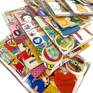Puede incluir: Una colecci&oacute;n de ef&iacute;meras de papel vintage, que incluye tarjetas, pegatinas y marcadores. Los art&iacute;culos presentan ilustraciones de animales, personas y varios dise&ntilde;os. Algunas tarjetas tienen el texto "Valentine Greetings". Los art&iacute;culos est&aacute;n empaquetados en pl&aacute;stico transparente.