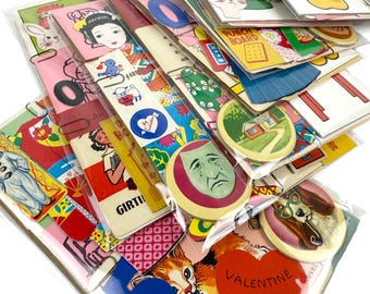 Op de afbeelding: Een verzameling vintage papieren ephemera, waaronder kaarten, stickers en bladwijzers. De items bevatten illustraties van dieren, mensen en diverse ontwerpen. Sommige kaarten hebben de tekst "Valentine Greetings". De items zijn verpakt in doorzichtig plastic.