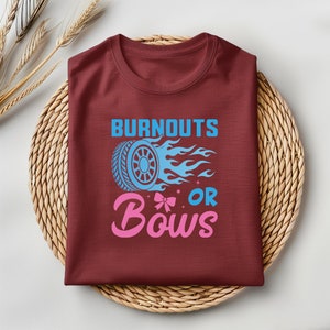 May include: A maroon t-shirt with the text "Burnouts or Bows" in blue and pink. The text is accompanied by a blue tire with flames and a pink bow.