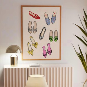May include: A framed illustration of nine pairs of shoes in various colors and patterns, including red, blue, green, yellow, pink, and black. The shoes are all different styles, including flats, loafers, and sandals.
