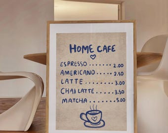 May include: A framed menu for a cafe called "Home Cafe" with a handwritten list of coffee drinks and prices. The menu includes espresso, americano, latte, chai latte, and matcha. The prices are listed in US dollars. A small illustration of a coffee cup with steam and a heart is at the bottom of the menu.