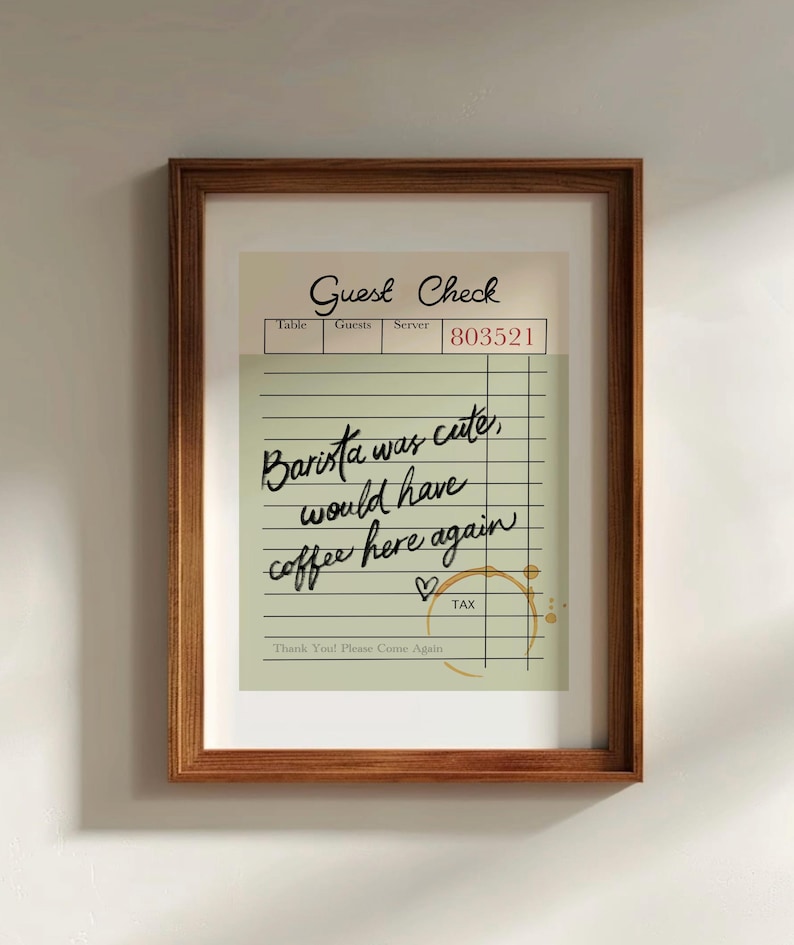 May include: A framed print of a vintage-style guest check with handwritten text that reads "Barista was cute, would have coffee here again." The check has a brown coffee stain and a heart drawn next to the text "TAX".