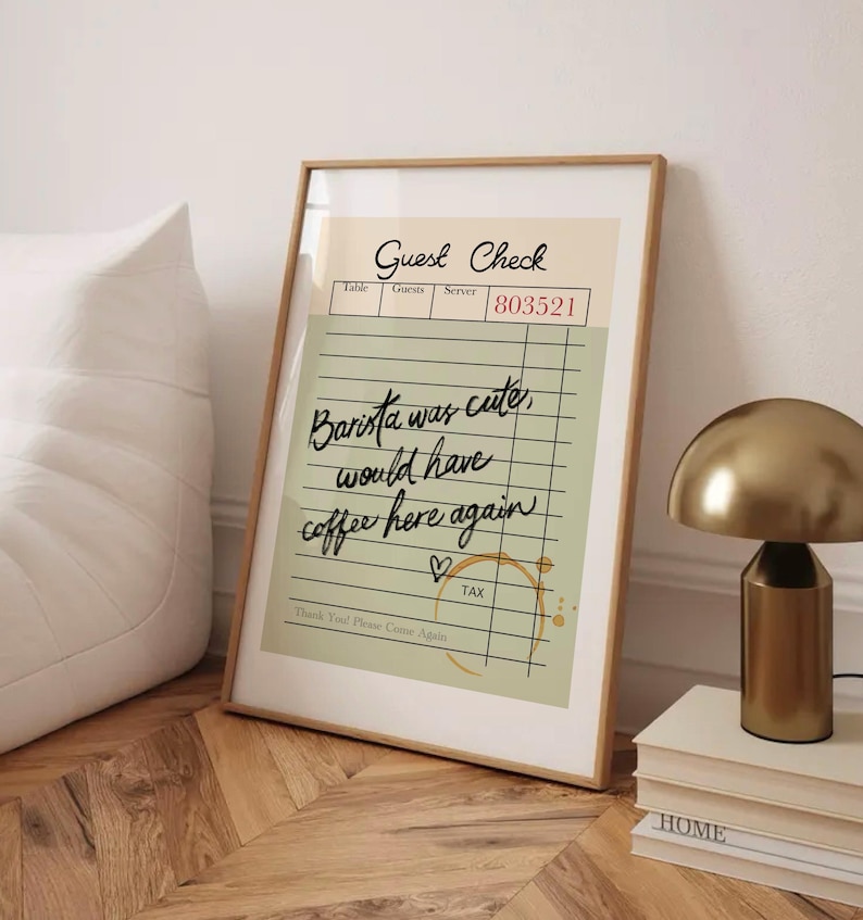 May include: A green and white guest check with the text "Guest Check" and "Barista was cute, would have coffee here again" written in black cursive. The check has a brown coffee stain and a heart drawn in black.