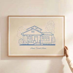 Puede incluir: Una impresi&oacute;n enmarcada de un dibujo lineal de una casa con un fondo beige. La casa es azul y tiene un porche delantero con una puerta y ventanas. El texto "Home Sweet Home" est&aacute; escrito debajo de la casa.