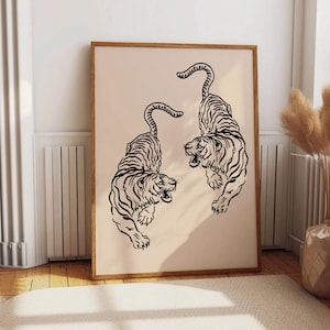 May include: A black and white line art print of two tigers facing opposite directions. The tigers are in a dynamic pose, with their tails curled up and their heads turned to the side. The print is on a light beige background.