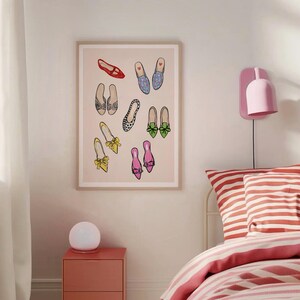 May include: A framed print of a collection of colorful shoes with different patterns and styles. The shoes are arranged in a random pattern on a light pink background.