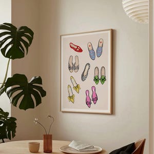 May include: A framed print featuring a collection of colorful and patterned shoes. The shoes are arranged in a whimsical pattern on a light pink background.