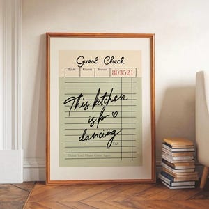 Puede incluir: Un diseño de arte de pared imprimible verde y blanco con un mensaje escrito a mano que dice "This kitchen is for dancing". El diseño está estilizado para parecerse a un cheque de restaurante vintage.
