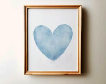 May include: A framed print of a light blue watercolor heart on a white background.