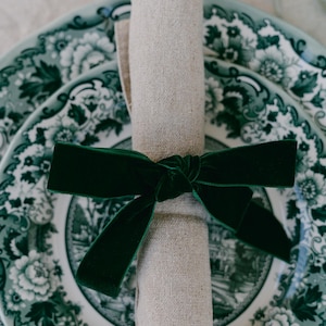 Green, bow napkin rings in a Christmas table setting of green toile plates.