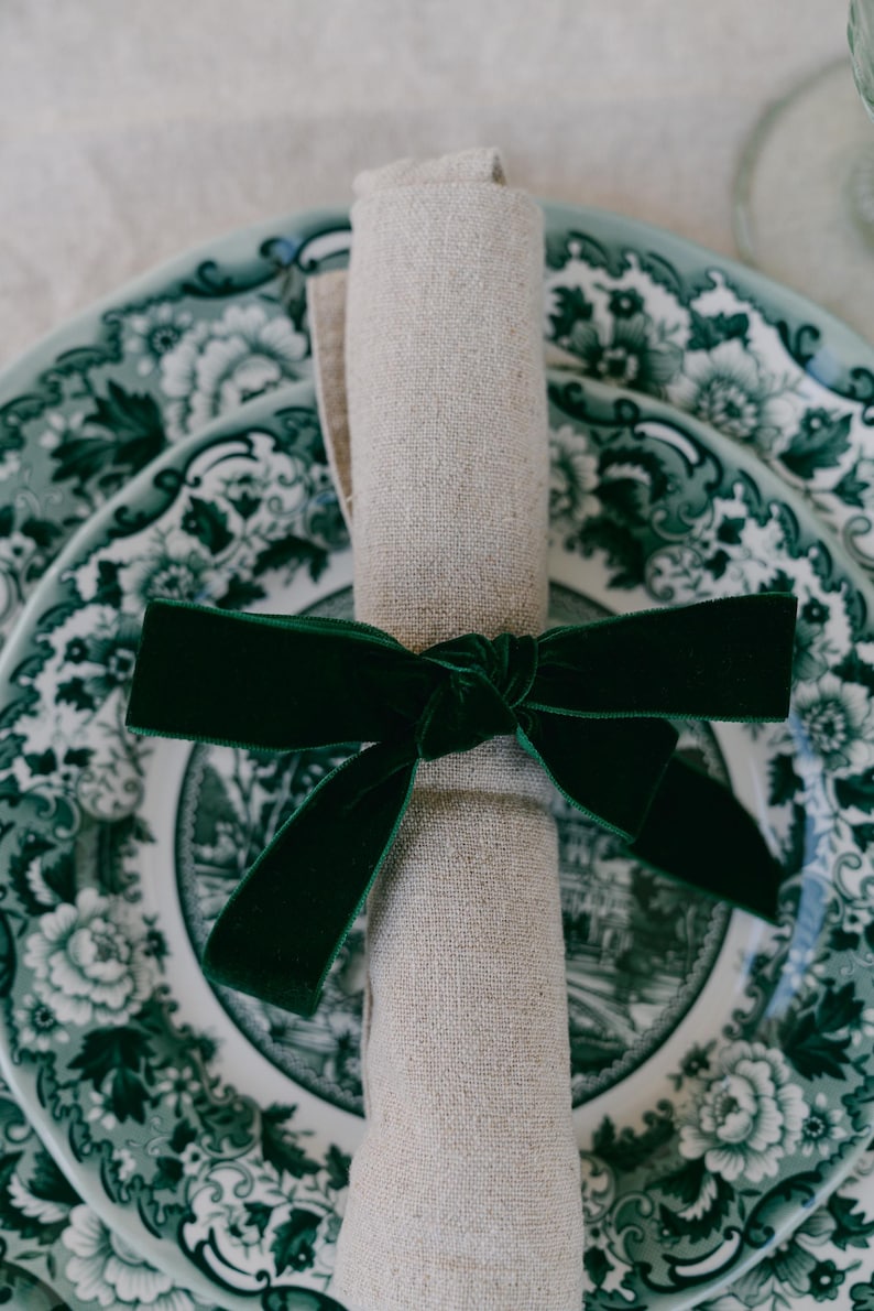 Green, bow napkin rings in a Christmas table setting of green toile plates.