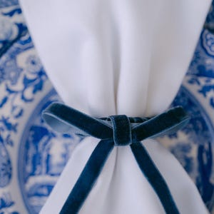 Blue, thin bow napkin rings in a Christmas table setting.