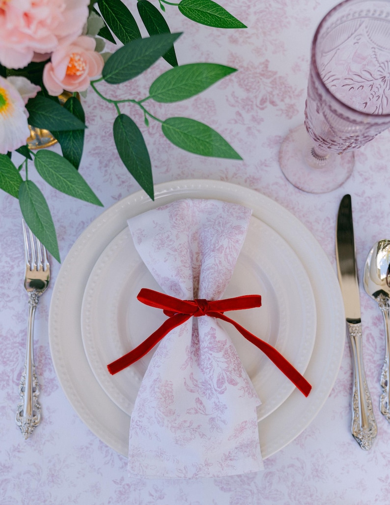 Thin, red, bow napkin rings in a Christmas table setting.