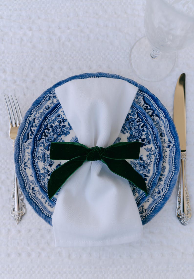 Blue, bow napkin rings in a Christmas table setting of blue Tonkin plates.