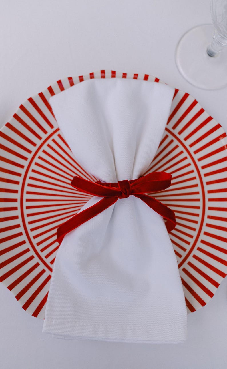Thin, red, bow napkin rings in a Christmas table setting.