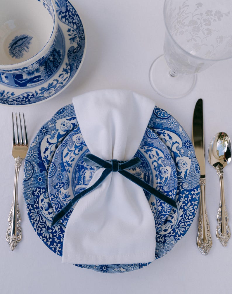 Blue, bow napkin rings in a Christmas table setting of blue italian plates.