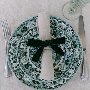 Green, bow napkin rings in a Christmas table setting of green toile plates.