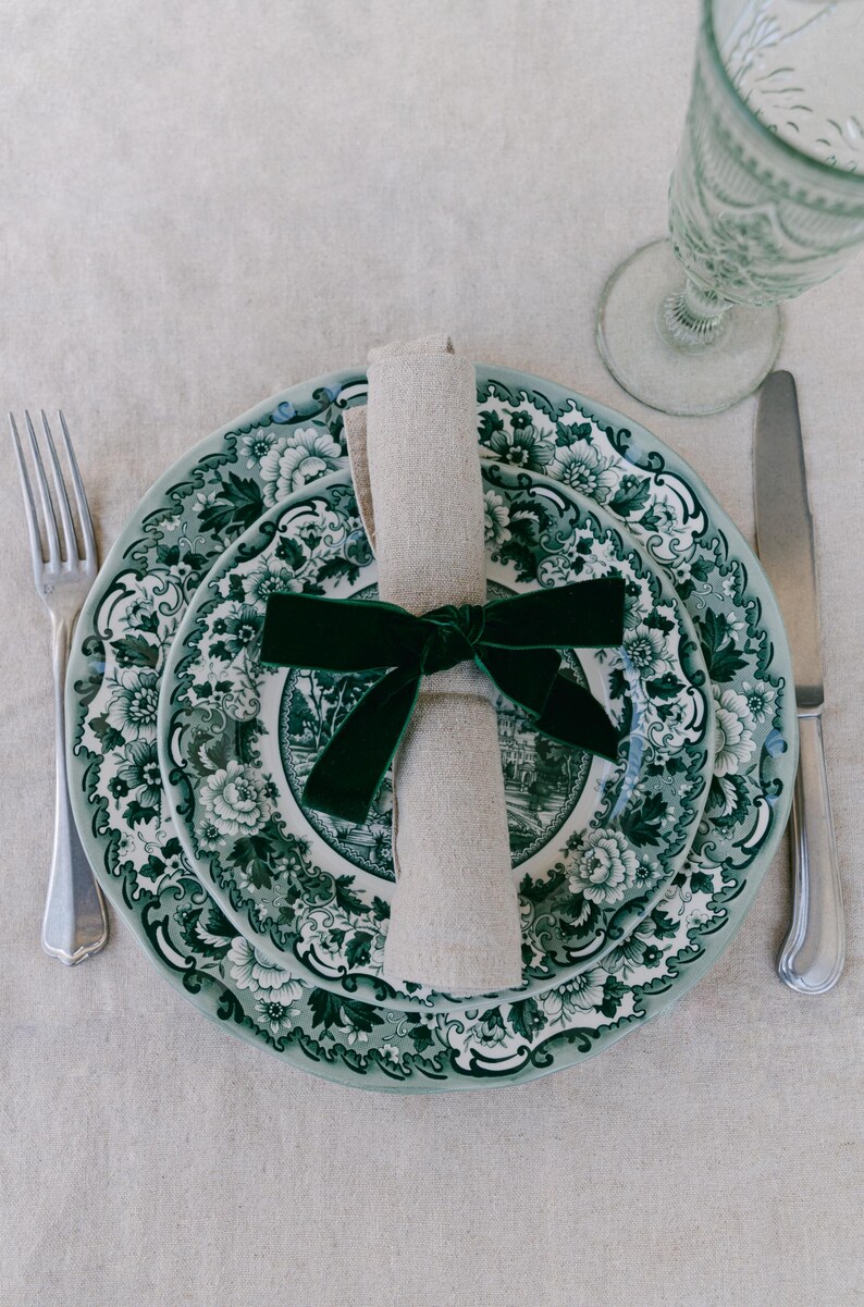 Green, bow napkin rings in a Christmas table setting of green toile plates.