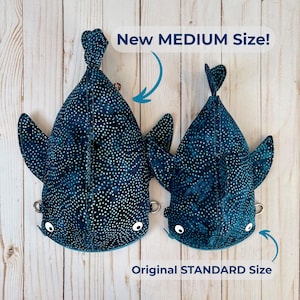 May include: Two shark-shaped plush toys in dark blue fabric with white polka dots. The larger toy is labelled "New MEDIUM Size!" and the smaller one "Original STANDARD Size." Both have white eyes and small metal rings.
