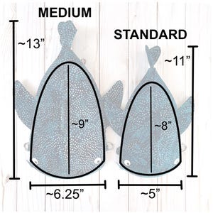 May include: Two fabric whale shark-shaped bags, one labeled "MEDIUM" and the other "STANDARD." The medium bag is approximately 33 cm tall, 23 cm wide, and 16 cm across. The standard bag is approximately 28 cm tall, 20 cm wide, and 13 cm across.