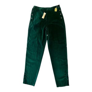 May include: Emerald green velvet pants with button details on the sides and ankles. The high-waisted pants have a straight leg cut and a tag attached. A classic, elegant style.