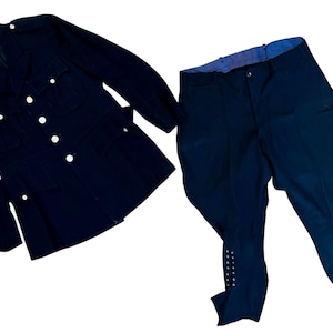 May include: A navy blue uniform jacket with white buttons and a matching pair of navy blue riding pants. The pants have decorative buttons along the lower leg. The jacket has multiple pockets.