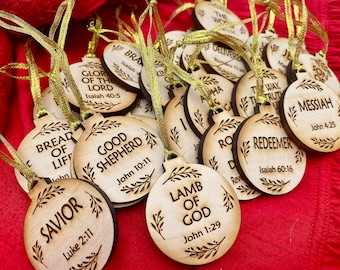 May include: A collection of wooden ornaments with religious quotes and scripture verses. The ornaments are round and have a rustic, natural wood finish. Each ornament features a different quote, such as "Bread of Life", "Good Shepherd", "Lamb of God", and "Redeemer".
