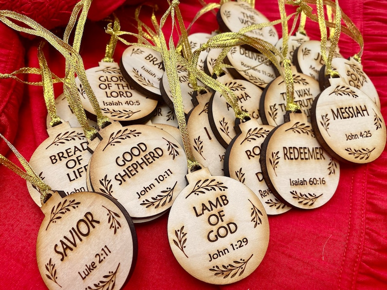 May include: A collection of wooden ornaments with religious quotes and scripture verses. The ornaments are round and have a rustic, natural wood finish. Each ornament features a different quote, such as "Bread of Life", "Good Shepherd", "Lamb of God", and "Redeemer".