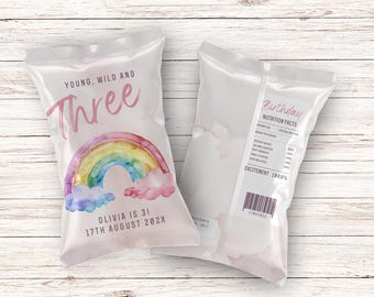 May include: Two clear plastic bags with a rainbow design and the text "Young, Wild and Three" and "Olivia is 31, 17th August 202X". The back of one bag has the text "Birthday Nutrition Facts" and a barcode.