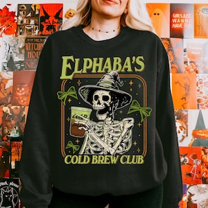 Elphaba’s Cold Brew Club Sweatshirt, Wicked Defying Gravity Hoodie, Broomstick Magic Wand, Gift for Fan, Halloween Sweatshirt, Wizard of Oz