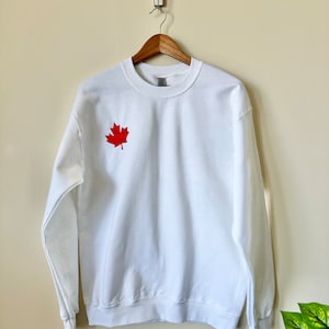 Canada Day Maple Leaf bestickte Sweatshirt, hochwertiges Merch, erhältlich in Weiß auf Rot und Rot auf Weiß.