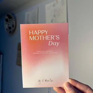 May include: A Mother's Day card with a gradient pink and orange background. The card reads "HAPPY MOTHER'S Day" in large letters, with the message "THANK YOU FOR BEING THE BEST MOM EVER, EVER, EVER" below. Signed "by V. Martin".