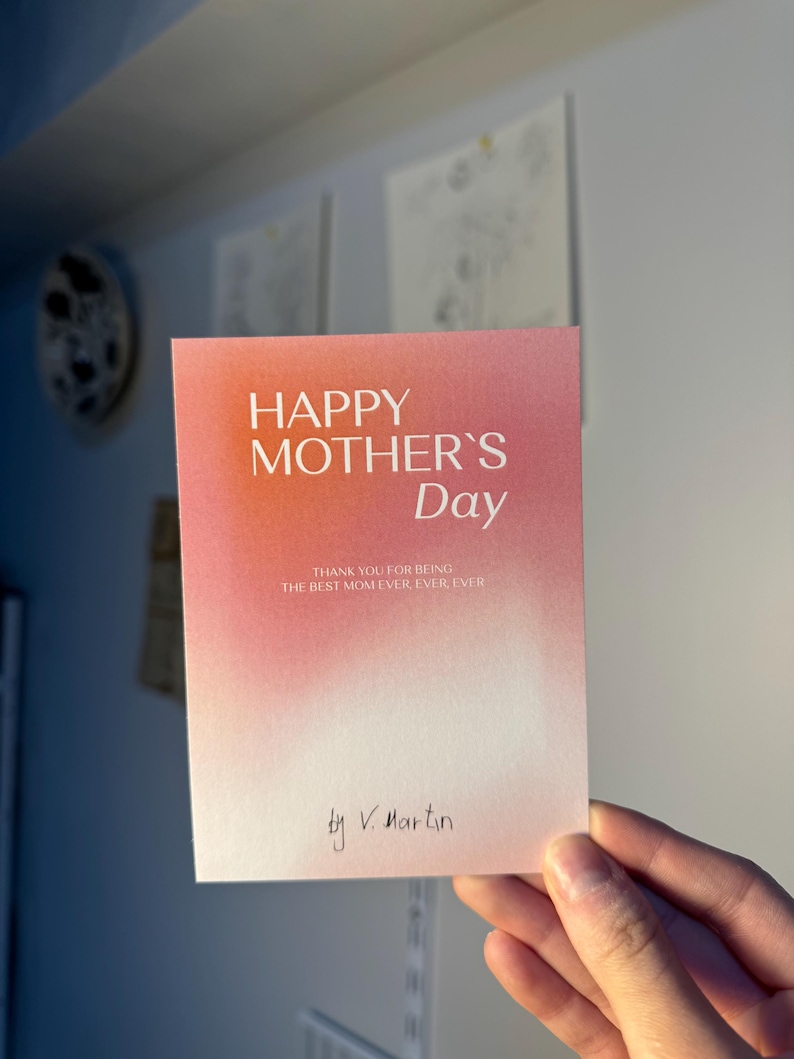 May include: A Mother's Day card with a gradient pink and orange background. The card reads "HAPPY MOTHER'S Day" in large letters, with the message "THANK YOU FOR BEING THE BEST MOM EVER, EVER, EVER" below. Signed "by V. Martin".