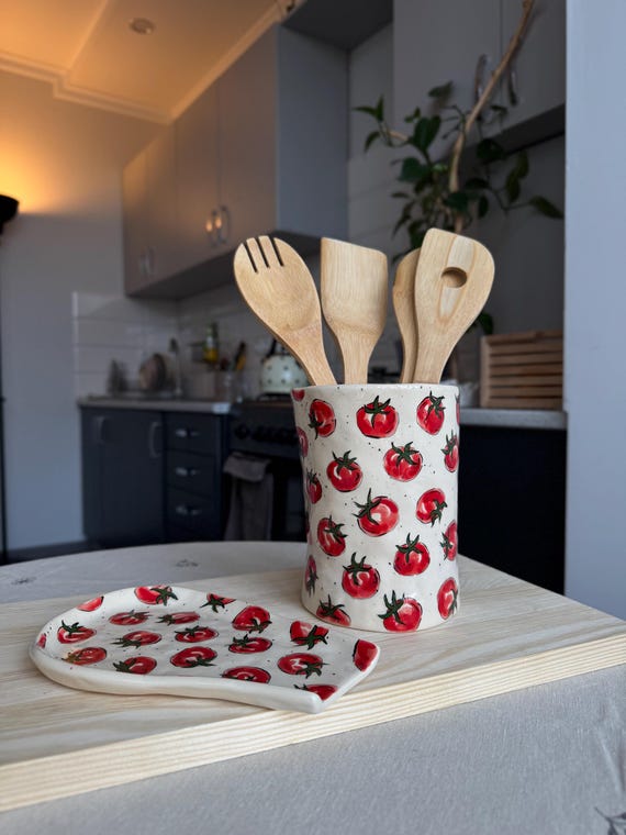 An organic-shaped ceramic spoon rest sculpted to look like a tomato — genuinely artisan, cottagecore-perfect, and 24 favorites prove people are swooning over it.