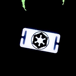 May include: White plastic key chain with a black Imperial symbol from Star Wars.