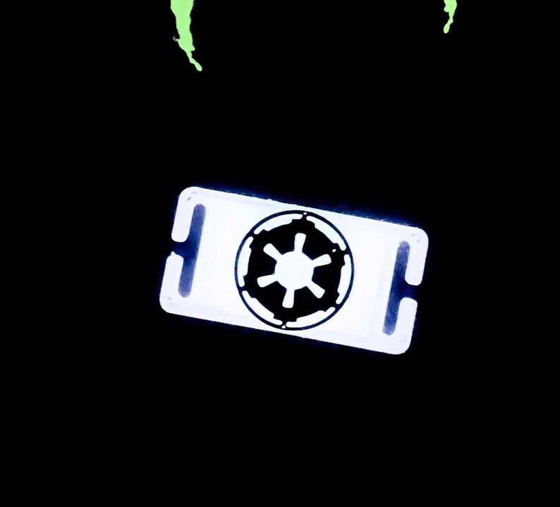May include: White plastic key chain with a black Imperial symbol from Star Wars.